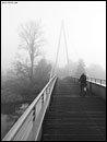 Radfahrerin auf dem Katzengrabensteg im Nebel